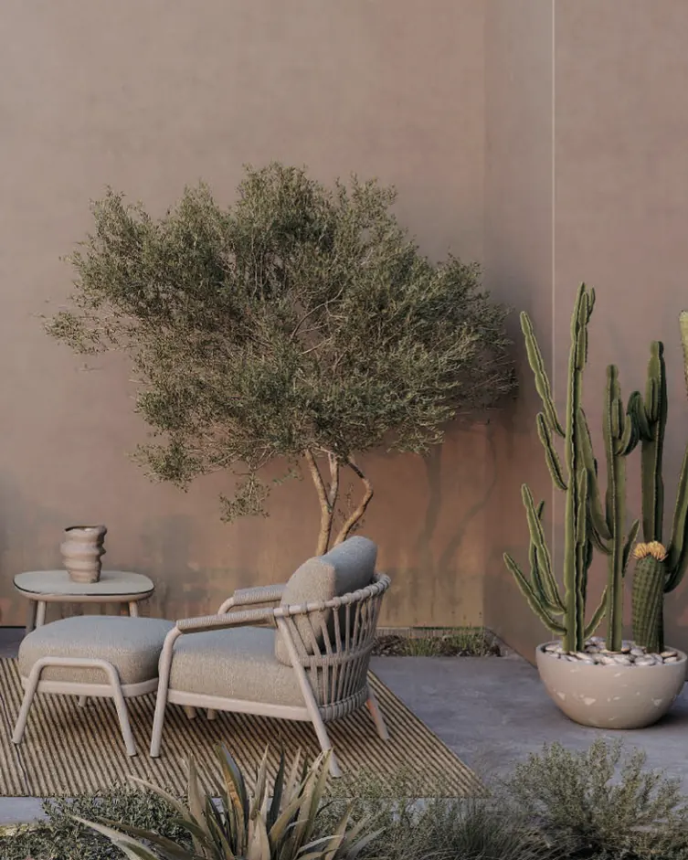 Lounge chair and ottoman beside an olive tree on a courtyard patio, shown in black and white